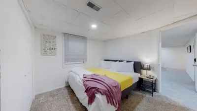 a white bedroom with a bed and a window at Cozy Mountain-Inspired Lower Unit in Denver in Denver