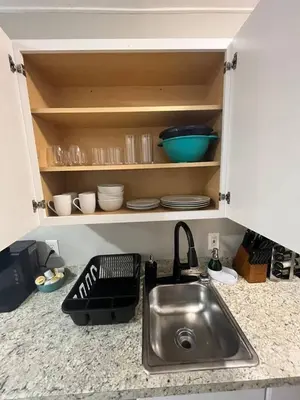 a kitchen counter with a sink and some bowls and plates at Spacious Studio with King Bed & Fast WiFi in Denver