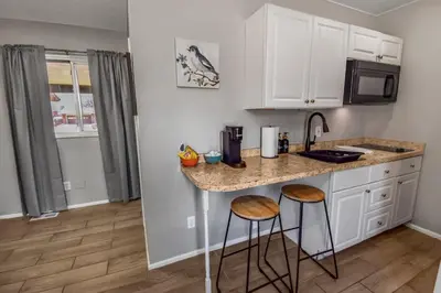 a kitchen with a counter and two stools at a kitchen island at Spacious Studio with King Bed & Fast WiFi in Denver