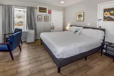 a bedroom with a large bed and a blue chair at Spacious Studio with King Bed & Fast WiFi in Denver
