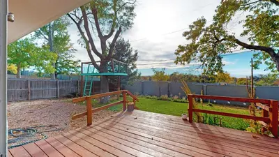 a wooden deck with a tree and a playground at Enchanting Upper Unit with City Charm in Denver