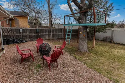 a group of red chairs sitting around a tree at Enchanting Upper Unit with City Charm in Denver