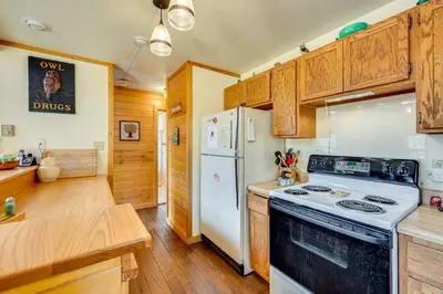 a kitchen with a white stove and a refrigerator at 4 Mi to RMNP Allenspark Cabin with Wraparound Deck! in Allenspark
