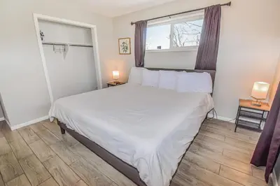 a bedroom with a large white bed and a window at Awesome Two Bedroom Family Upper Unit in Denver in Denver