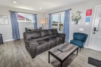 a living room with a brown leather couch and a blue chair at Awesome Two Bedroom Family Upper Unit in Denver in Denver