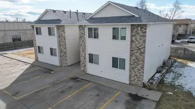 a white house with a garage in a parking lot at Great Two King Bed Rooms Near Airport Ideal Stay in Brighton