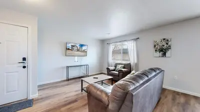 a living room with a leather couch and a table at Great Two King Bed Rooms Near Airport Ideal Stay in Brighton