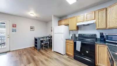 a kitchen with black appliances and wooden cabinets at Great Two King Bed Rooms Near Airport Ideal Stay in Brighton