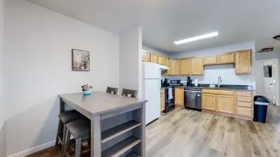 a kitchen with wooden cabinets and a table with chairs at Great Two King Bed Rooms Near Airport Ideal Stay in Brighton