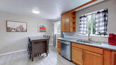 a kitchen with a sink and a table in it at Arvada Private Family Home with Two King Beds in Arvada