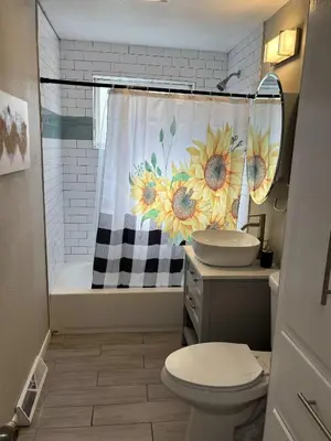 a bathroom with a sink and a shower curtain with sunflowers at Arvada Private Family Home with Two King Beds in Arvada