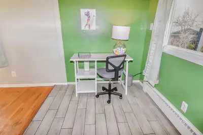 a desk with a lamp and a chair in a room at Family Home with Large Yard & Golf Theme Near Rail in Denver