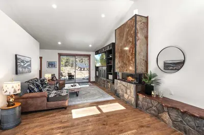 a living room with a couch and a stone fireplace at 34 Acre Escape Games Hiking Pool Table Bicycles in Black Hawk