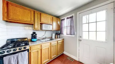 a kitchen with wooden cabinets and a stove top oven at Cool Stay Near Rapids Stadium Ideal for Sports Fans in Commerce City