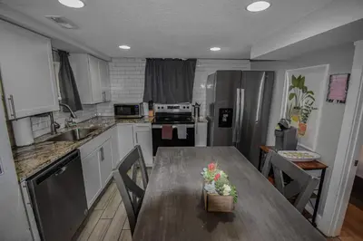 a kitchen with a wooden table and a kitchen with a counter at Fun and Affordable Dual Bedroom Lower Unit in Vibrant Denver in Denver