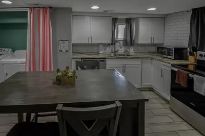 a kitchen with white cabinets and a large counter top at Fun and Affordable Dual Bedroom Lower Unit in Vibrant Denver in Denver