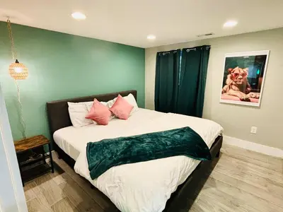 a bedroom with a large bed with pink pillows at Fun and Affordable Dual Bedroom Lower Unit in Vibrant Denver in Denver