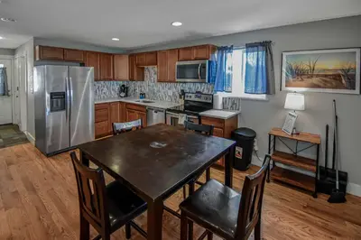 a kitchen with a table and a stainless steel refrigerator at Cozy and Budget Friendly Single Bedroom in the Heart of Denver in Denver