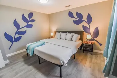 a bedroom with a bed with blue flowers on the wall at Vibrant & Cozy Two Bedroom Lower Unit King Beds in Denver