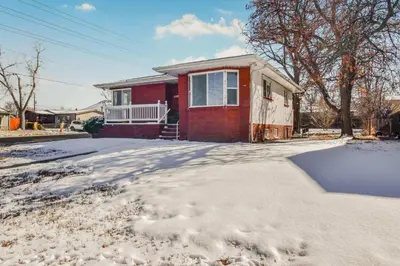 a red house with snow on the driveway at Vibrant & Cozy Two Bedroom Lower Unit King Beds in Denver