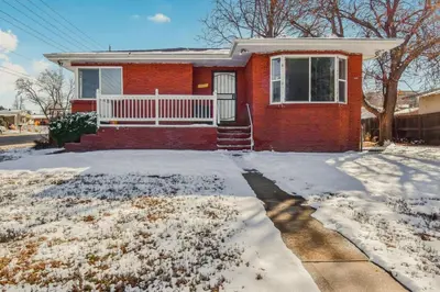 a red brick house with snow on the ground at Family Friendly & Cozy Two Bedroom Denver in Denver