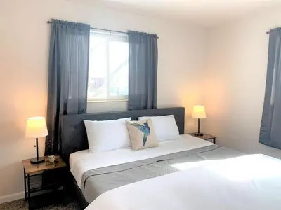 a bedroom with a bed with two lamps and a window at Family Friendly & Cozy Two Bedroom Denver in Denver