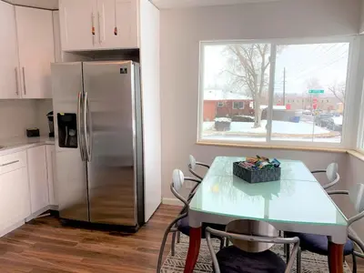 a kitchen with a table and a stainless steel refrigerator at Family Friendly & Cozy Two Bedroom Denver in Denver