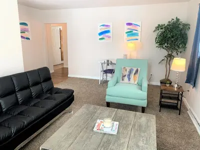 a living room with a black couch and a blue chair at Family Friendly & Cozy Two Bedroom Denver in Denver