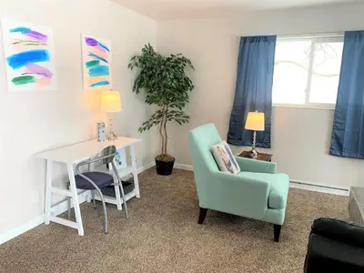 a living room with a desk and a chair and a table at Family Friendly & Cozy Two Bedroom Denver in Denver