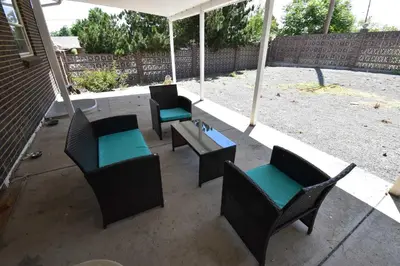 a patio with chairs and tables and an umbrella at Updated Family Unit with Two King Beds in Denver