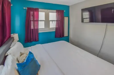 a bedroom with a white bed and a window at Cozy upper unit great for family visiting Zoo medica campus and downtown in Denver