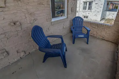two blue chairs sitting next to a brick wall at Cozy upper unit great for family visiting Zoo medica campus and downtown in Denver