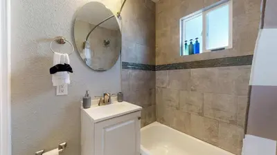 a bathroom with a sink and a mirror at Cozy upper unit great for family visiting Zoo medica campus and downtown in Denver