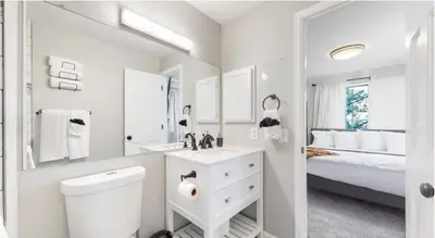 a white bathroom with a toilet and a bed at Updated Two-Bedroom with Three King Beds Loft & Two Baths in Aurora