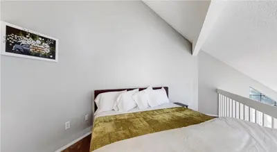 a bedroom with a bed in a white room at Updated Two-Bedroom with Three King Beds Loft & Two Baths in Aurora