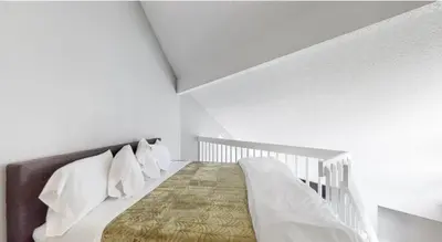 a white bedroom with a bed and a staircase at Updated Two-Bedroom with Three King Beds Loft & Two Baths in Aurora