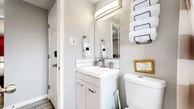 a bathroom with a sink and a toilet and towels at Cozy King Bed Hideaway Near Top Concerts & Sports in Commerce City