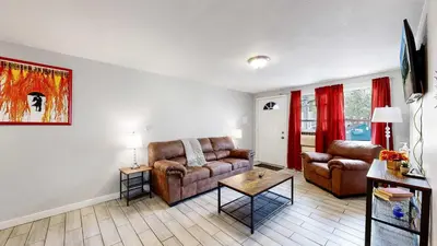 a living room with two couches and a table at Cozy King Bed Hideaway Near Top Concerts & Sports in Commerce City
