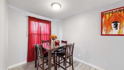a dining room with a table and chairs and a red window at Cozy King Bed Hideaway Near Top Concerts & Sports in Commerce City