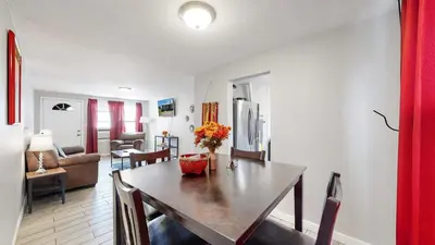 a dining room with a table and a living room at Cozy King Bed Hideaway Near Top Concerts & Sports in Commerce City