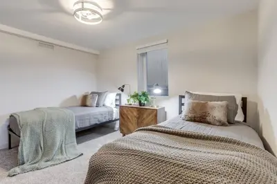 a white bedroom with a bed and a window at Charming Central Denver Bungalow With Hot Tub in Denver
