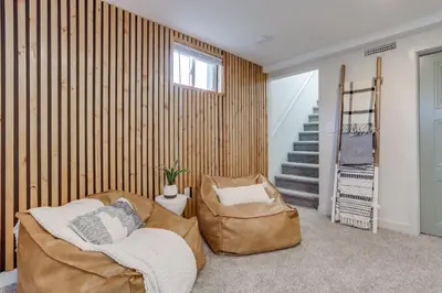 a living room with two chairs and a staircase at Charming Central Denver Bungalow With Hot Tub in Denver