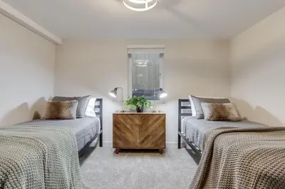 a bedroom with two beds and a table with a plant at Charming Central Denver Bungalow With Hot Tub in Denver
