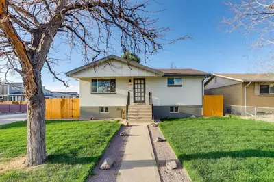 a house with a tree and a sidewalk at Charming Central Denver Bungalow With Hot Tub in Denver
