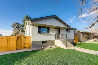 a white house with a wooden fence at Charming Central Denver Bungalow With Hot Tub in Denver