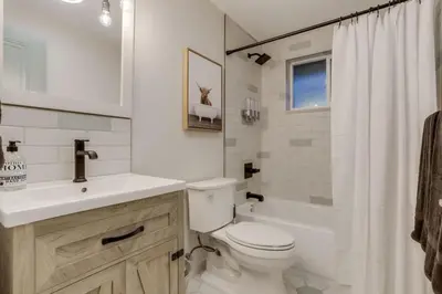 a bathroom with a toilet and a sink and a tub at Charming Central Denver Bungalow With Hot Tub in Denver