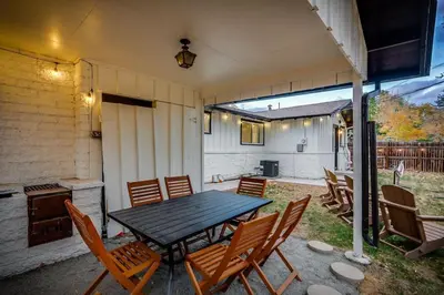 a patio with a wooden table and chairs at The Western Retreat With Hot Tub and Spacious Yard in Westminster