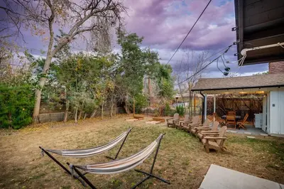 two hammocks sitting in a yard with a group of benches at The Western Retreat With Hot Tub and Spacious Yard in Westminster