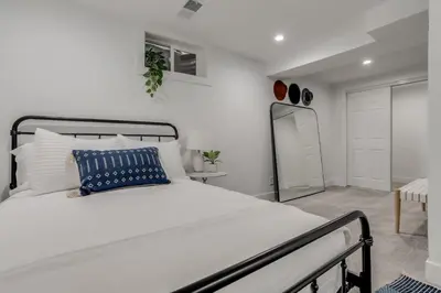 a bedroom with a large white bed with a blue pillow at The Western Retreat With Hot Tub and Spacious Yard in Westminster