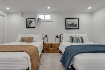 two beds in a room with white walls at The Western Retreat With Hot Tub and Spacious Yard in Westminster